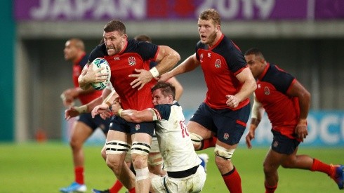 Mark Wilson de Inglaterra supera a AJ MacGinty de EE UU, durante el partido del Grupo C del Mundial de Rugby en Kobe.