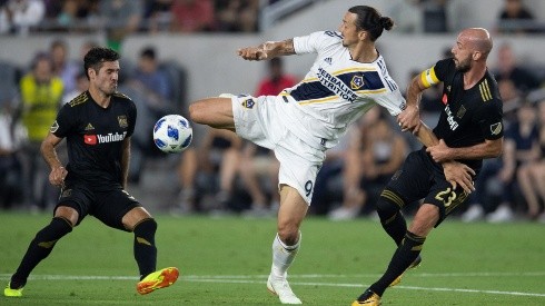 Los Angeles Galaxy forward Zlatan Ibrahimovic (9) fights for the ball against Los Angeles FC midfielder Benny Feilhaber (33) and defender Laurent Ciman (23) during the first half of a Major League Soccer match at Banc of California Stadium in Los Angeles, Calif. on Thursday July 26, 2018.  (Photo by Raul Romero Jr, Contributing Photographer)