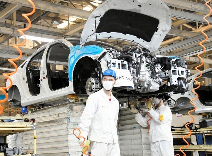 Los trabajadores de esta fábrica automotriz regresaron a sus lugares, usando mascarillas como precaución. (Foto: Getty Images).
