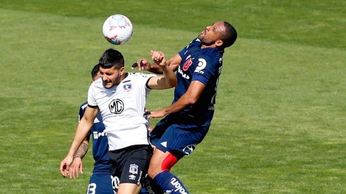 Jean Beausejour disputa el balón con Nicolás Blandi