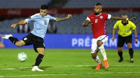 Maximiliano Gómez empalma el balón ante el asedio de Arturo Vidal, para anotar el gol de la victoria de Uruguay sobre Chile en Montevideo