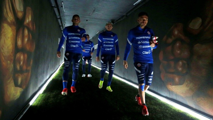 Sebastián Vegas, Diego Valdés y Charles Aránguiz cruzan el túnel de acceso a la cancha David Arellano del estadio Monumental en 2021