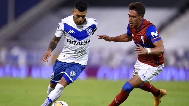 Lucas Janson lucha una pelota con Diego Valencia. ¿Será refuerzo de la U. de Chile el jugador de Vélez Sarsfield?
