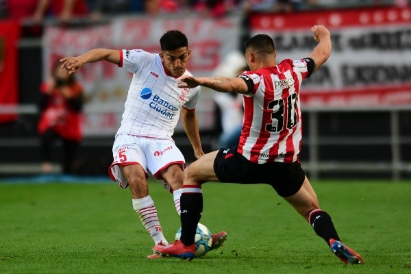 Juan Fuentes (30) traba ante César Ibáñez en un partido entre Estudiantes y Huracán. (Foto: Getty Images)