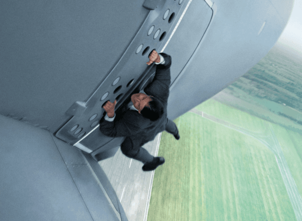Tom Cruise colgando de un avión de carga en “Mission Impossible: Rogue Nation”.