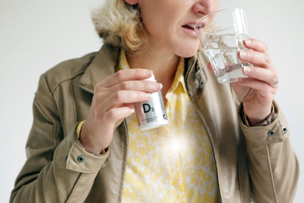 Mujer tomando vitamina D Mujer tomando vitamina D