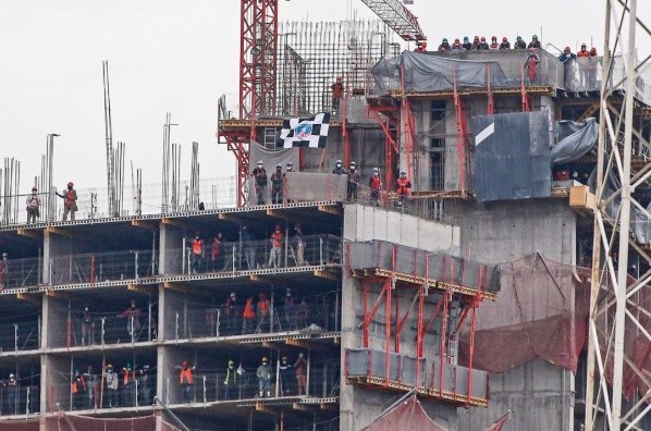 Obreros alientan a Colo Colo desde un edificio en construcción. | Foto: Seba Órdenes