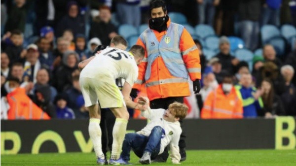 Stuart Dallas levanta a un niño que ingresó al campo | Foto: Getty Images.