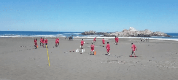 El plantel de Ñublense tuvo una intensa pero distinta jornada de entrenamiento en la playa de Cobquecura, hasta donde llegaron algunos hinchas a alentarlos. (Foto: Captura Canal 9 Bio Bio)