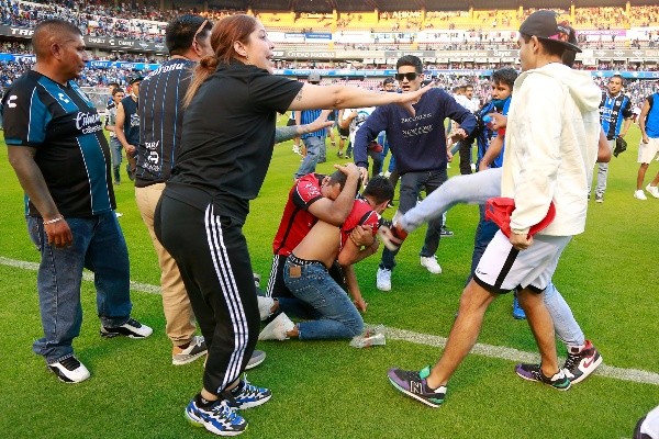 Hinchas de Atlas tuvieron que protegerse de las agresiones de parte de gente del Querétaro. (Foto: Jam Media)
