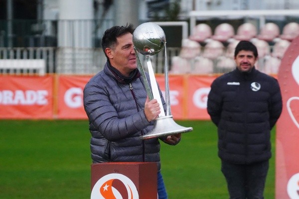 Eduardo Berizzo camina con la copa del Torneo Proyección Sub 21. De atrás lo mira Jorge Guerrero, Director de Desarrollo Técnico de la ANFP. Foto: Guille Salazar.