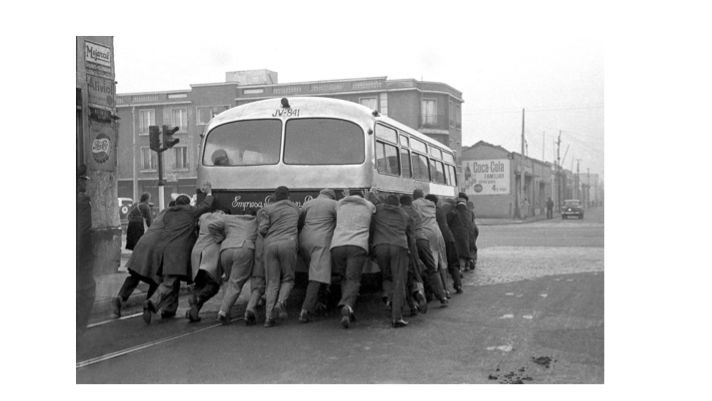 Una veintena de pasajeros empujan un bus de la locomoción colectiva en una calle de Santiago. Foto: Cedida.