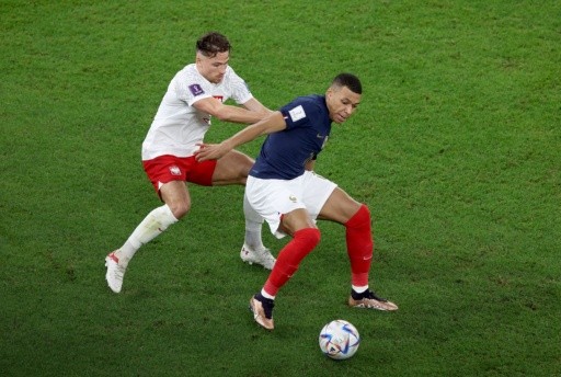 Matty Cash intenta marcar al francés Kylian Mbappé, quien fue figura ante Polonia. (Getty Images 2022).