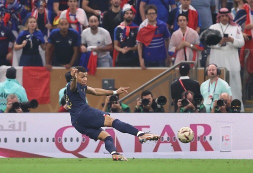 Kylian Mbappé impacta el balón para anotar el segundo de los tres tantos que le anotó con Francia a Argentina en la gran final de Qatar 2022. (Getty Images).