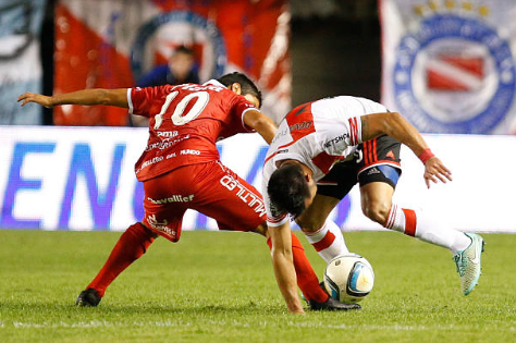 Luciano Cabral traba una pelota a Ariel Rojas en un partido entre Argentinos Juniors y River Plate. (Getty Images).