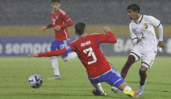 Leenhan Romero en acción ante Chile: ahí enfrenta al defensor de Palestino Iván Román.